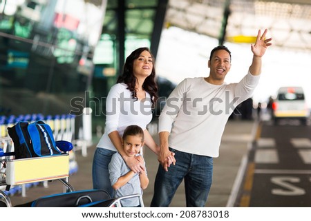 handsome man and his family hailing taxi at airport