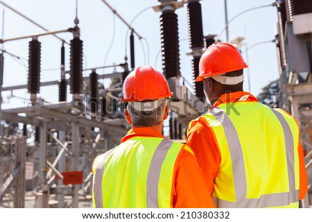 back view of two electrical engineers in substation