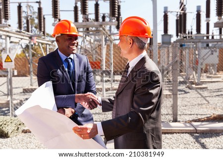 friendly business partners handshaking in electrical substation
