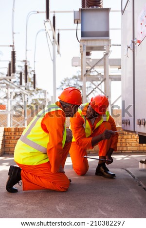 professional power company electrical co-workers in substation
