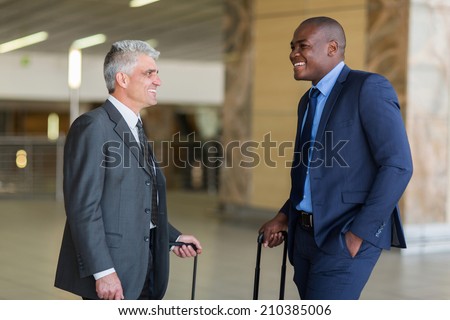 two friendly businessmen talking at airport