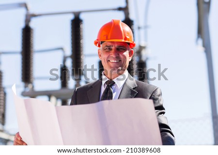 good looking middle aged electrical manager with blueprint