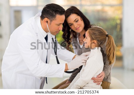 caring medical doctor examining a little girl in office