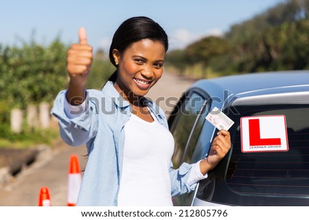 attractive african learner driver holding her driver\'s license