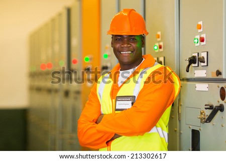 professional african industrial technician in front of control panel