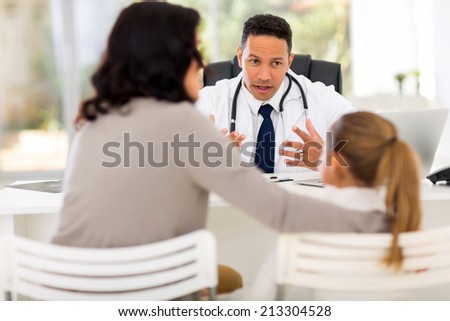 middle aged pediatrician consulting little patient in office