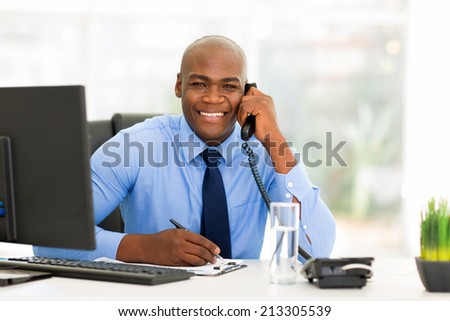 portrait of handsome male african office worker talking on phone