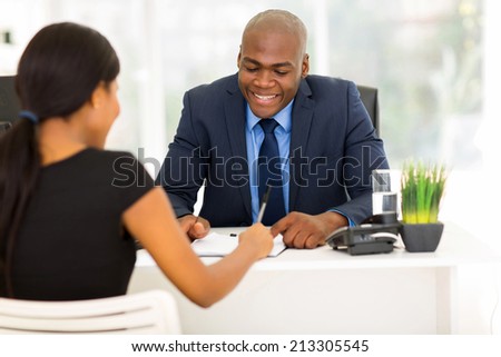 back view of african woman signing employment contract in office