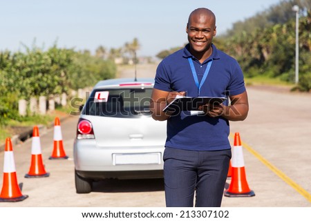 portrait of african american driving instructor writing on clipboard
