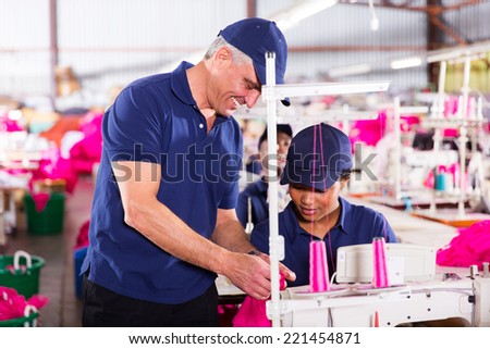 clothing factory quality controller checking stitch on production line