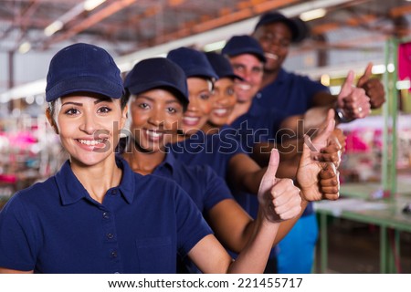 cheerful textile workers team giving thumbs up