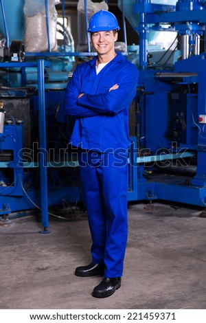 blue collar industrial worker with arms crossed in factory