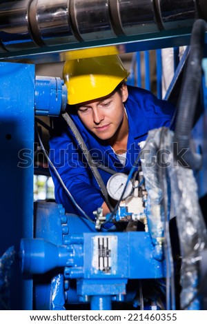industrial machine operator checking on machinery