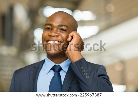 cheerful african american businessman talking on cell phone