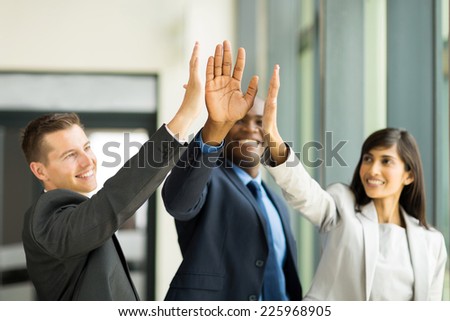 happy business team giving high five in office