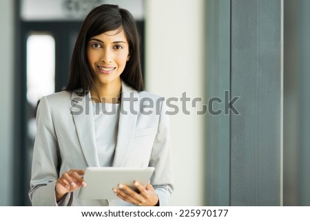 portrait of happy indian career woman using tablet pc