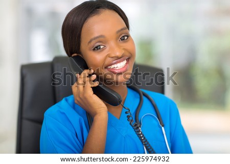 attractive african medical doctor talking on telephone
