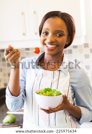 portrait of happy african american girl eating green salad