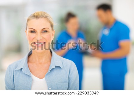 smiling middle aged woman waiting for checkup in doctor\'s office