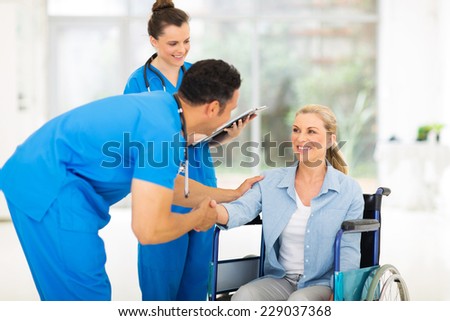 caring male doctor greeting handicapped patient