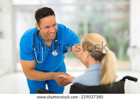 friendly healthcare worker handshaking handicapped woman