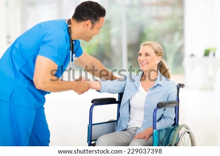 friendly mid age medical doctor greeting disabled patient
