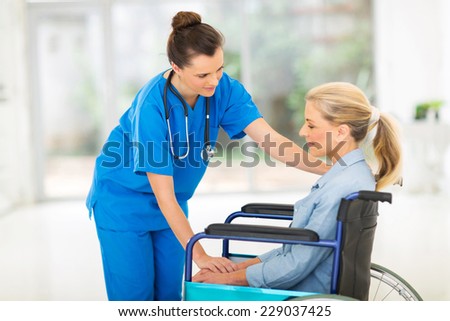 caring young female doctor comforting a sad disabled senior patient