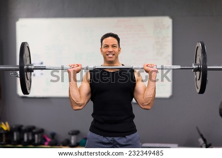 muscular man lifting weights in health club