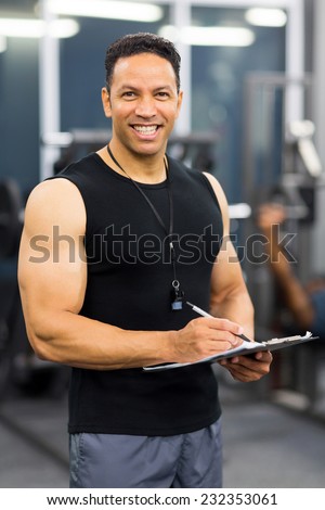 handsome middle aged personal trainer inside gym
