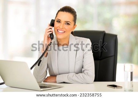 beautiful young businesswoman talking on landline phone