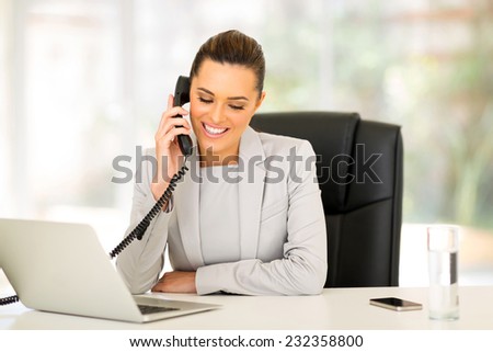 happy businesswoman using landline phone