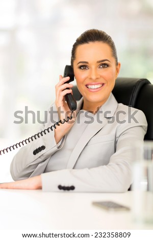 cheerful corporate worker talking on telephone in office