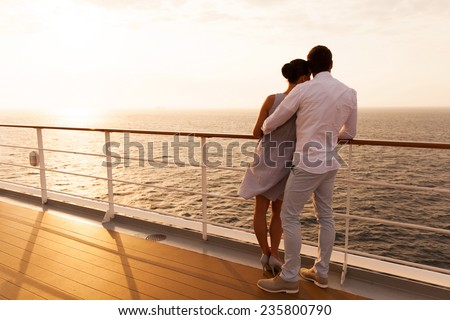 back view of young couple hugging at sunset on cruise ship