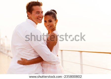 beautiful newlywed couple looking back on cruise