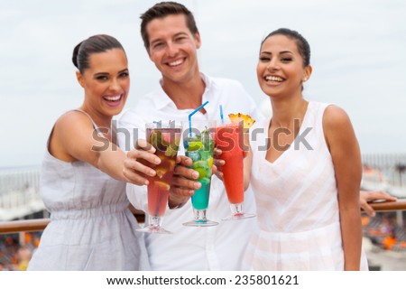 portrait of young people toasting with cocktail drinks on a cruise ship