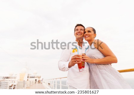 low angle view of cute young couple with cocktail on cruise ship