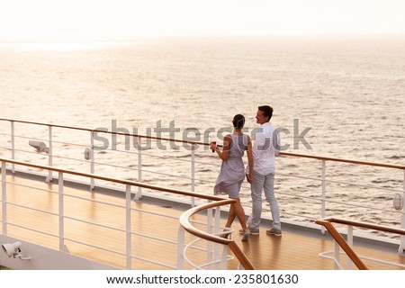 cute couple walking on cruise ship deck at sunset