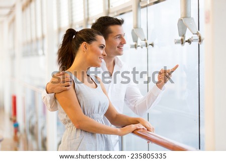 happy young couple at restaurant pointing outside