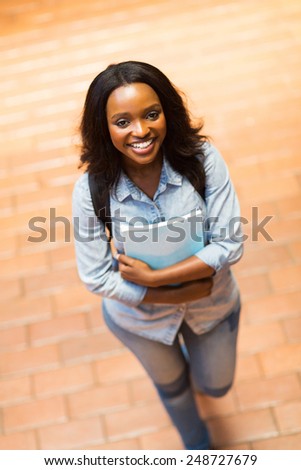 cheerful young african american college girl walking on campus