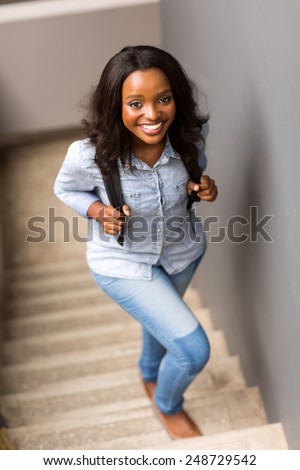 beautiful african college girl walking up the stairs on campus