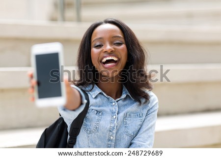 cheerful female university student showing smart phone