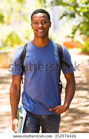 good looking male african college student walking on campus