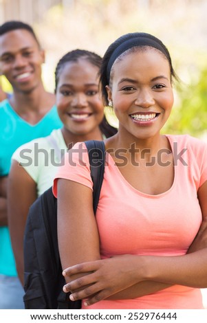 pretty african american college girl with friends on background