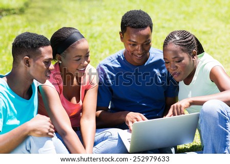 group of african university students using laptop outdoors