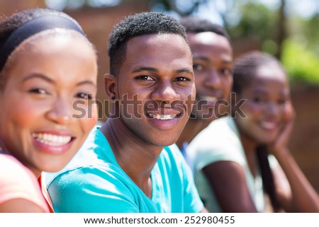 handsome afro american college boy sitting with friends