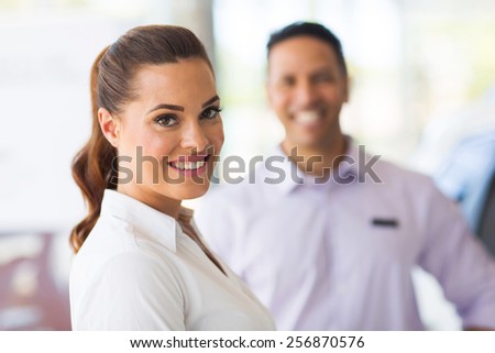 attractive vehicle sales woman standing in front of colleague
