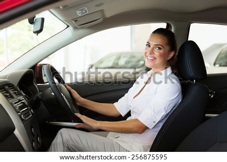 pretty young businesswoman sitting inside the car she just bought