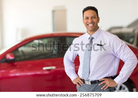middle aged vehicle sales consultant inside showroom