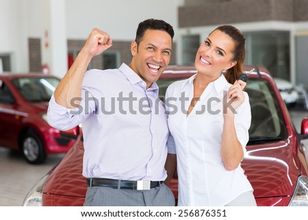 excited couple just bought a new car from dealership
