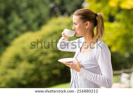 beautiful young woman drinking coffee outdoors